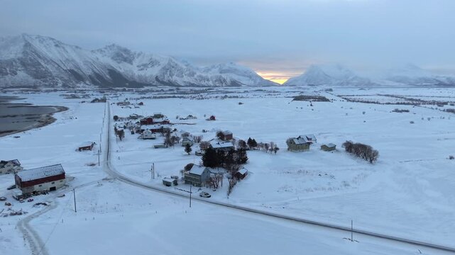 Drone moving right to left and camera moving left to right with snow falling in Lofoten, Norway.