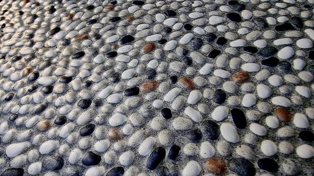 Natural pebble stone wall texture panning smoothly for cinematic video background overlay in 4K slow motion loop