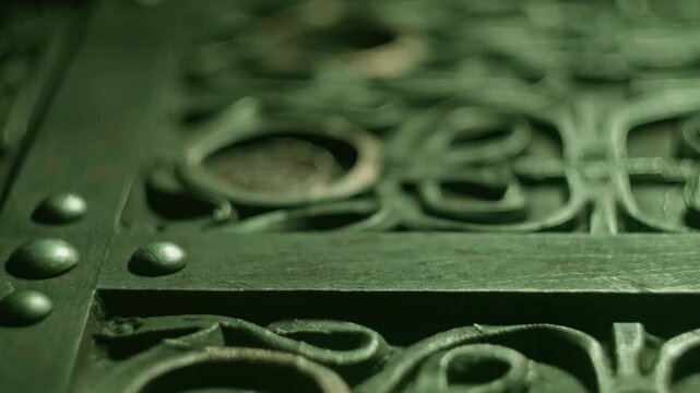 Ancient alien figurine resting inside ornate metal casket with intricate carvings under moody green atmospheric cinematic lighting.