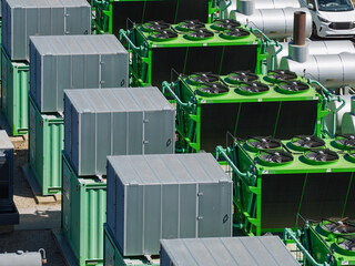 Multiple Modular Storage Containers and Green Cooling Systems Stand in a Modern Industrial Facility © Tom