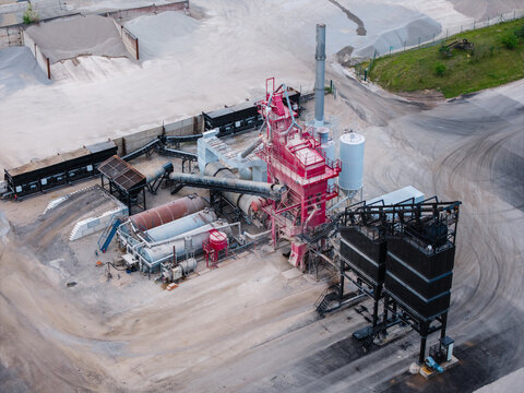 Aerial view of asphalt concrete production plant with industrial machinery, storage silos, and aggregate piles in a rural setting Tume Parish, Tukums Municipality, Latvia.