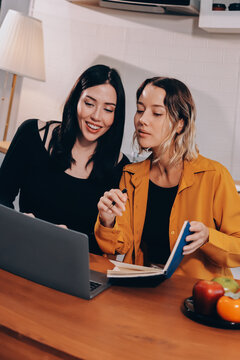 Portrait of military mother helping teen daughter with homework and eating lunch