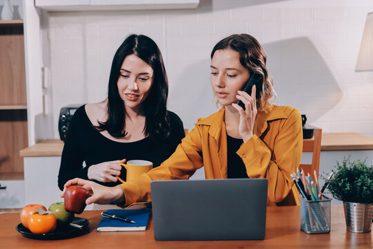 Portrait of military mother helping teen daughter with homework and eating lunch