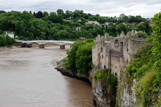 Chepstow Old Bridge spanning the River Wye framed by Chepstow Castle cliff tops Wales