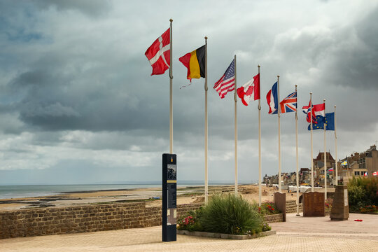National flags displayed along the coastal promenade in Saint Aubin sur Mer Normandy France