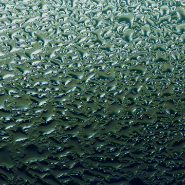 Condensation creating abstract water droplet texture on glass