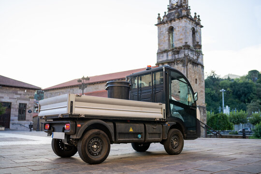 Compact electric utility truck on an old town square