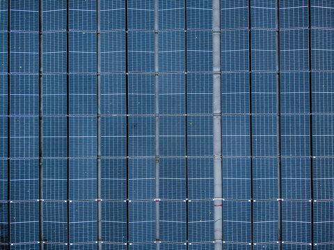Aerial view of solar panels arranged in rows on a rooftop, capturing the geometric pattern of the photovoltaic cells in Riga, Latvia.