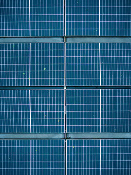 Aerial view of solar panels covered in raindrops, illustrating the challenges of renewable energy generation during rainy weather in Riga, Latvia.