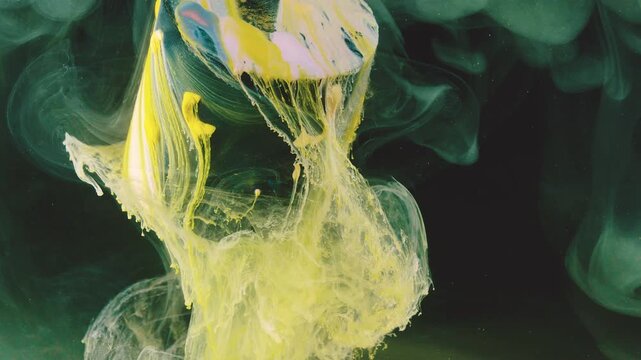 Close-up motion scene of neon yellow and pale lime pigment pouring and separating in dark tank, transforming from compact bulbs into cascading ribbons, stringy tendrils