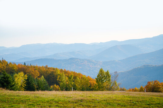 Panoramic landscape shot of autumn forest hills with hazy mountain peaks in the background
