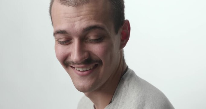 Close-up of Happy Young Man Turning and Laughing at Camera on White Background