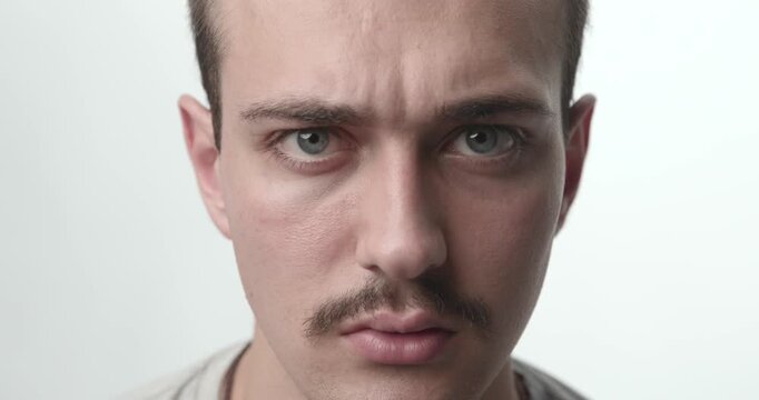 Extreme Close-up of Young Man with Confused and Skeptical Face Expression on White Background