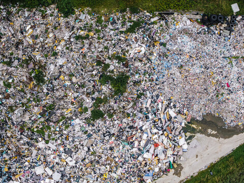 Aerial view of a municipal solid waste landfill with piles of sorted and unsorted refuse, debris, and discarded materials in Laidzes pagasts, Talsu novads, Latvia.