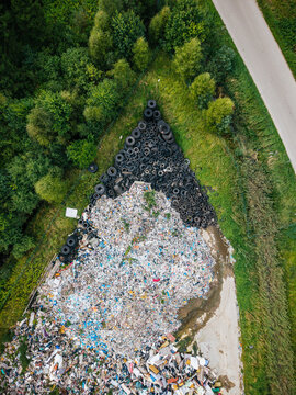 Aerial view of a large pile of discarded tires and mixed waste in a rural area near a road in Laidzes pagasts, Talsu novads, Latvia.