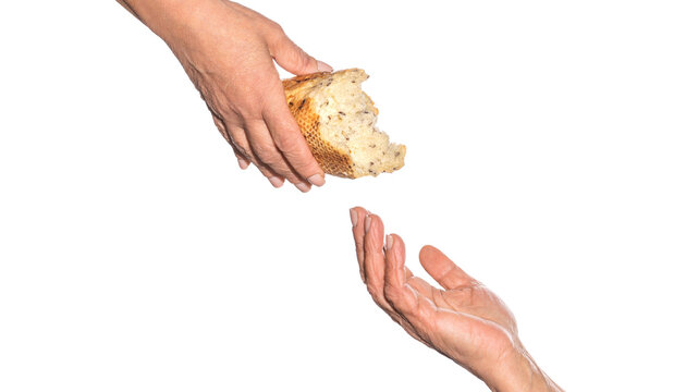 Old man giving poor homeless person pieces of bread. Helping the homeless. Elder woman hand give a loaf of bread to hands of a beggar. Poverty and world hunger concept. Hands grabbing for bread