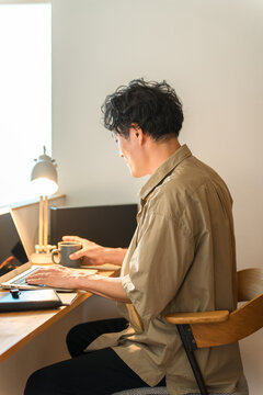 A middle-aged man working from home using a laptop computer.