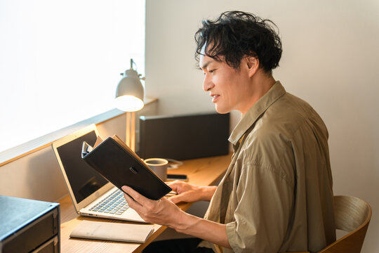 A middle-aged man working from home using a laptop computer.
