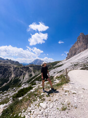 Naklejka premium Young woman exploring hiking trail in Dolomites near Tre Cime Dolomites Italy