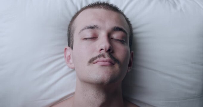 Top Down Portrait of Young Caucasian Man Sleeping Peacefully on White Pillow