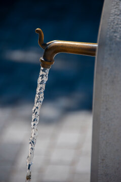 Water flowing from old brass street fountain tap