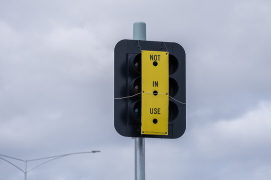 A newly installed traffic light covered with a yellow "NOT IN USE" sign&nbsp;in Melbourne, Victoria, Australia. Civic road infrastructure undergoing testing, installation, or upgrade