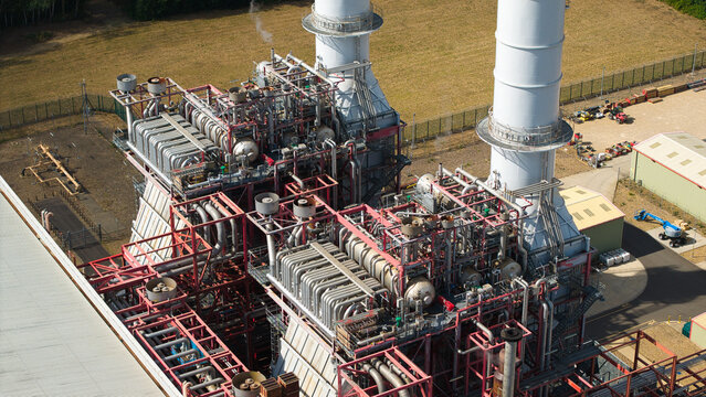 Aerial view of Sutton Bridge Power Station featuring prominent exhaust stacks and intricate mechanical components within the industrial facility in Sutton Bridge, England, United Kingdom.