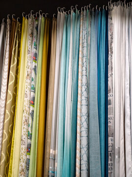 A variety of curtain designs in multiple colors hanging in a home goods store