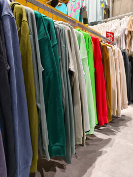 Assorted hooded sweatshirts hanging in a second hand store offer comfortable and versatile clothing for everyday use