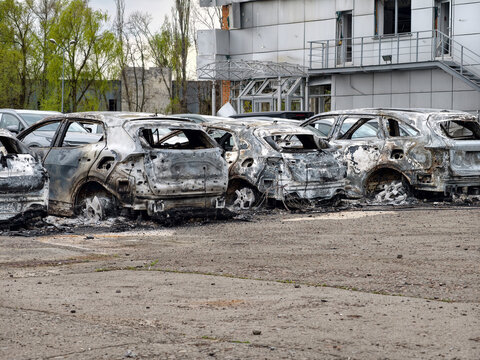 Cars burnt in a parking lot by missile strike. Ruined parking lot with cars destroyed by missile explosion