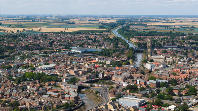 Aerial view of St Botolph's Church, known as The Stump, overlooking the historic town with its winding river and red brick rooftops in Boston, England, United Kingdom.