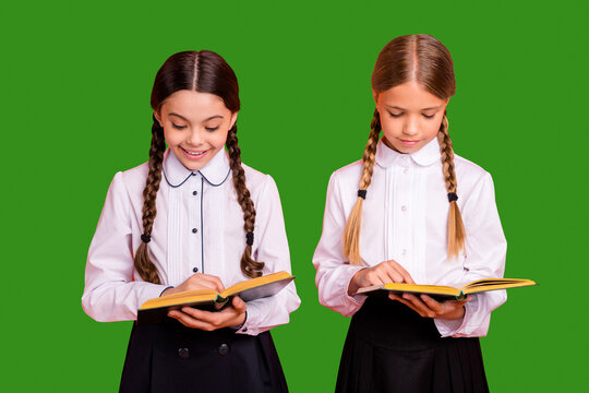 Portrait of two person nice attractive lovely charming cute cheerful focused concentrated pre-teen girls preparing test dictation isolated over bright vivid shine orange background