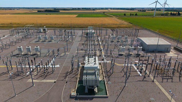 Aerial view of Triton Knoll offshore windfarm 400220kV substation featuring electrical transformers and switchgear equipment surrounded by agricultural fields in Boston, England, United Kingdom.