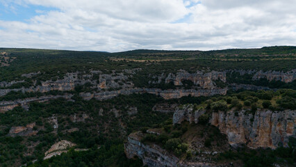 Obraz premium serene canyon landscape with rock formations and vegetation in rural setting viewed from aerial perspective, nature photography, Risco los camellos, Cascada de Orbaneja del Castillo