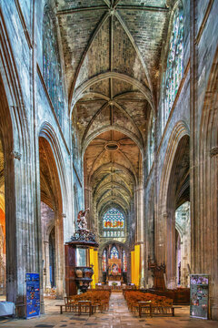Interior view of the Gothic Basilica of Saint Michael in Bordeaux, France. Soft indoor daylight illuminates ancient stone vaults