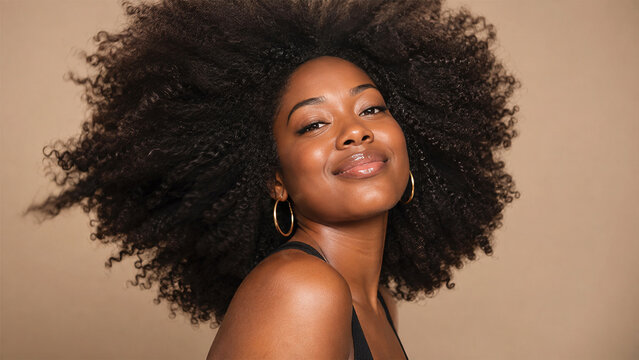Beautiful Black woman with voluminous natural afro hair posing confidently, elegant beauty portrait celebrating curls, healthy hair and natural hairstyle