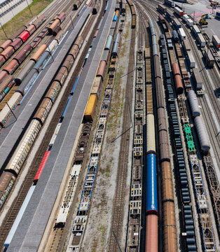 Aerial view of Chiasso Cargo Train Terminal with freight trains, cargo containers, and rail tracks arranged in parallel lines under bright daylight Chiasso, Ticino, Switzerland.