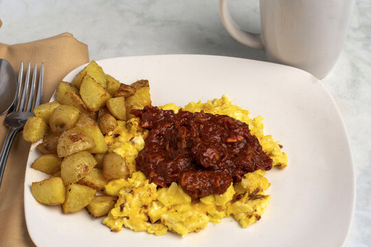 pulled pork  on scramble eggs with home fries