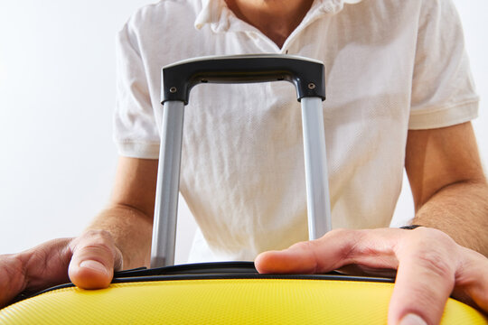Close-Up of Man Holding Yellow Suitcase Handle for Travel