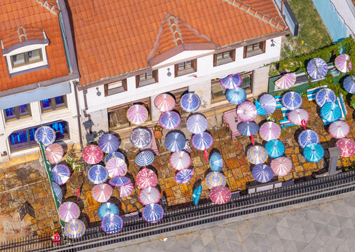 Aerial view of the Old Bazaar with colorful umbrellas shading an outdoor terrace on stone pavement in Skopje, Greater Skopje, North Macedonia.