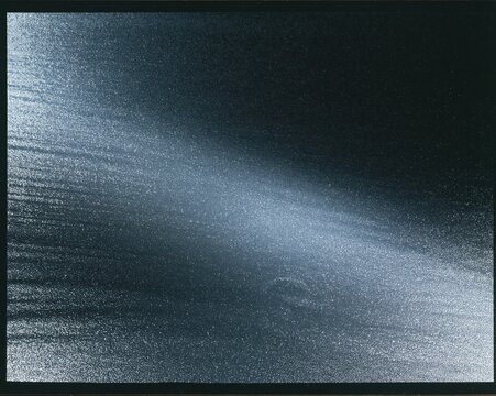Microprismatic retroreflective material with a sparkling silver texture and grey field, featuring a technical luminous glow for industrial backgrounds