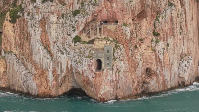 Porto Flavia Historic Mining Installation Carved Into A Sheer Limestone Rock Face Near Iglesias In Southwestern Sardinia, Italy. Aerial Drone Shot