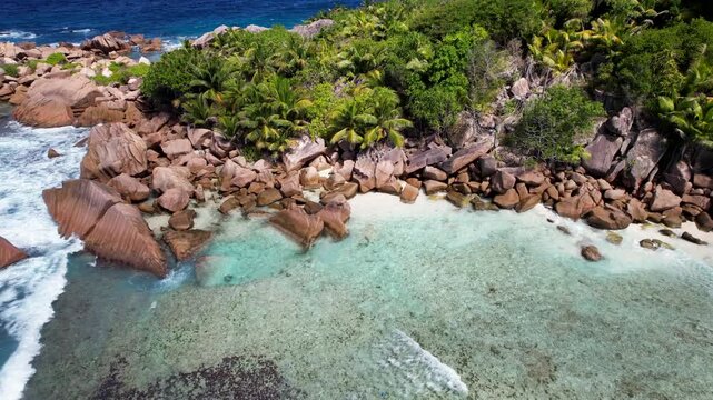Anse Cocos Beach reveals clear shallows on La Digue. Aerial
