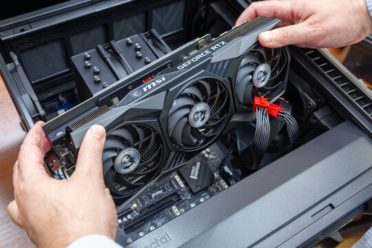 Technician installs a powerful expensive MSI GeForce RTX graphics card into a high-end gaming PC or graphics workstation. Pavlodar, Kazakhstan - December 15, 2025