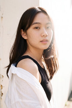 Natural backlit portrait of young woman in casual summer outfit with shoulder reveal for lifestyle banner and profile background