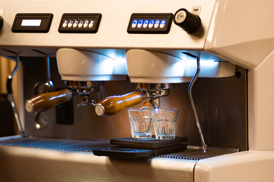 Close up horizontl picture of professional espresso machine brewing coffee into glasses on a scale. Real horizontal picture. Ideal for espresso coffe bar promotions. Coffe international Day