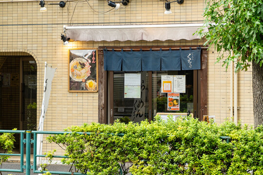 NAKANO-KU, TOKYO, JAPAN - AUGUST 30, 2026: Exterior view of Ramen Kumakura storefront with blue noren curtain in Nakano-ku, Tokyo.