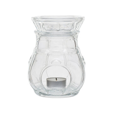 Clear glass essential oil burner with a decorative pattern and a small tea light candle inside, isolated on a white background