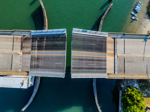 Aerial view of the Intracoastal Waterway drawbridge in the open position with boats nearby and clear water in Wrightsville Beach, North Carolina, United States.