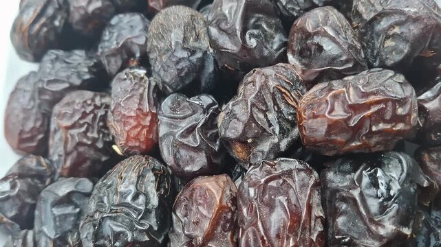 Ajwa dates fruit close up, premium organic dried dates pile, dark brown sweet palm dates for ramadan and healthy snacking